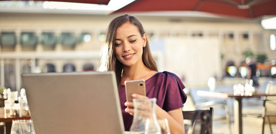 woman-wearing-purple-shirt-holding-smartphone-white-sitting-826349 (1)